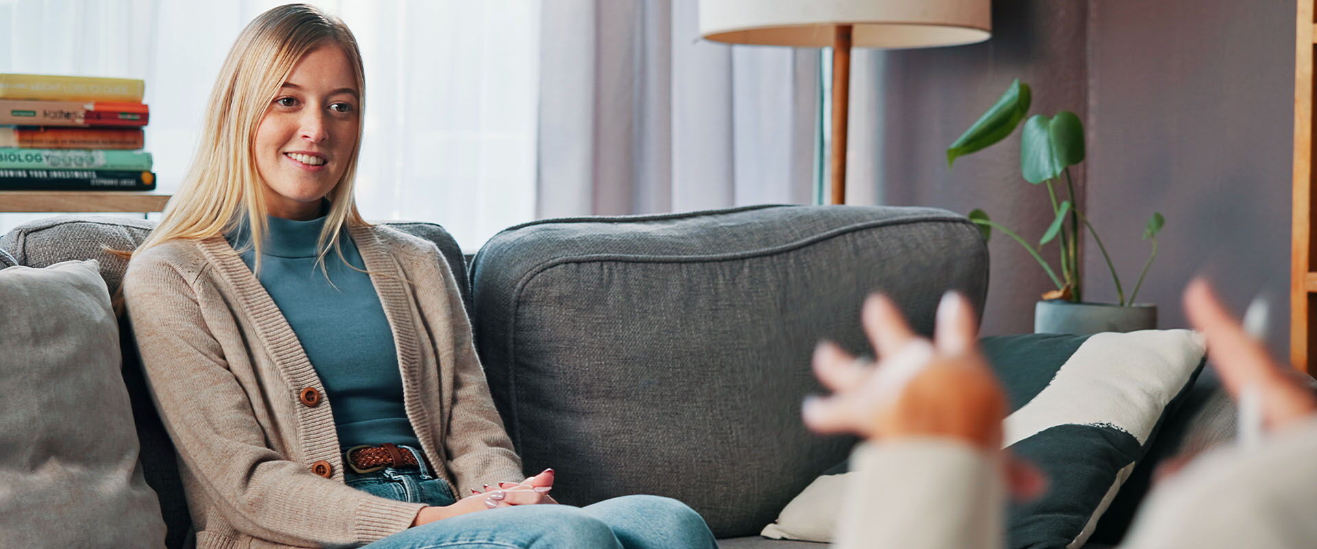 Blonde Frau sitztbei einer Beratung auf einem Sofa